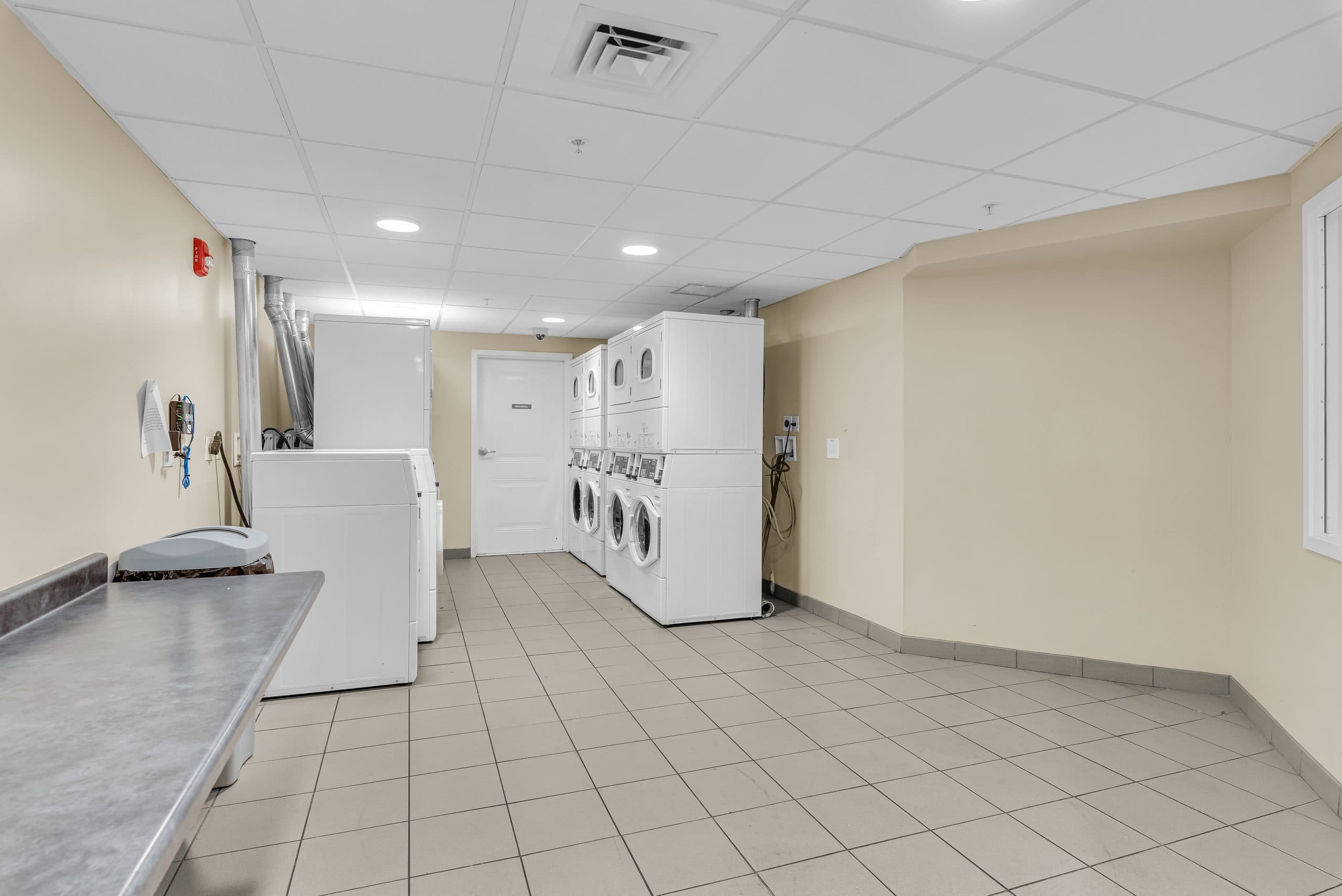 The shared laundry room, with stacked washers and dryers and a folding counter